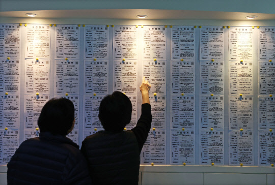 일자리는 어디에…  통계청이 지난 11일 발표한 '10월 고용동향'에 따르면 지난달 취업자 수는 2708만8000명으로, 1년 전보다 42만1000명 감소했다. 이날 오후 서울 성동구 희망일자리센터 앞에서 시민이 구인 정보를 살피고 있다.  연합뉴스